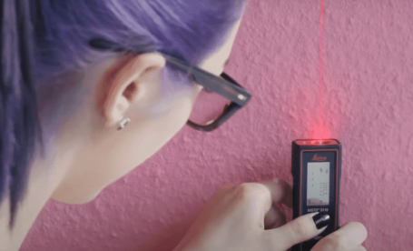 Woman using a Leica Disto laser distance meter.
